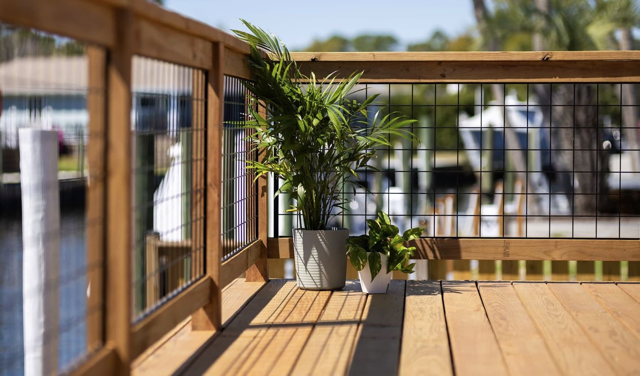Deck railing with decorative plants on composite wood surface in Spring Valley residential backyard